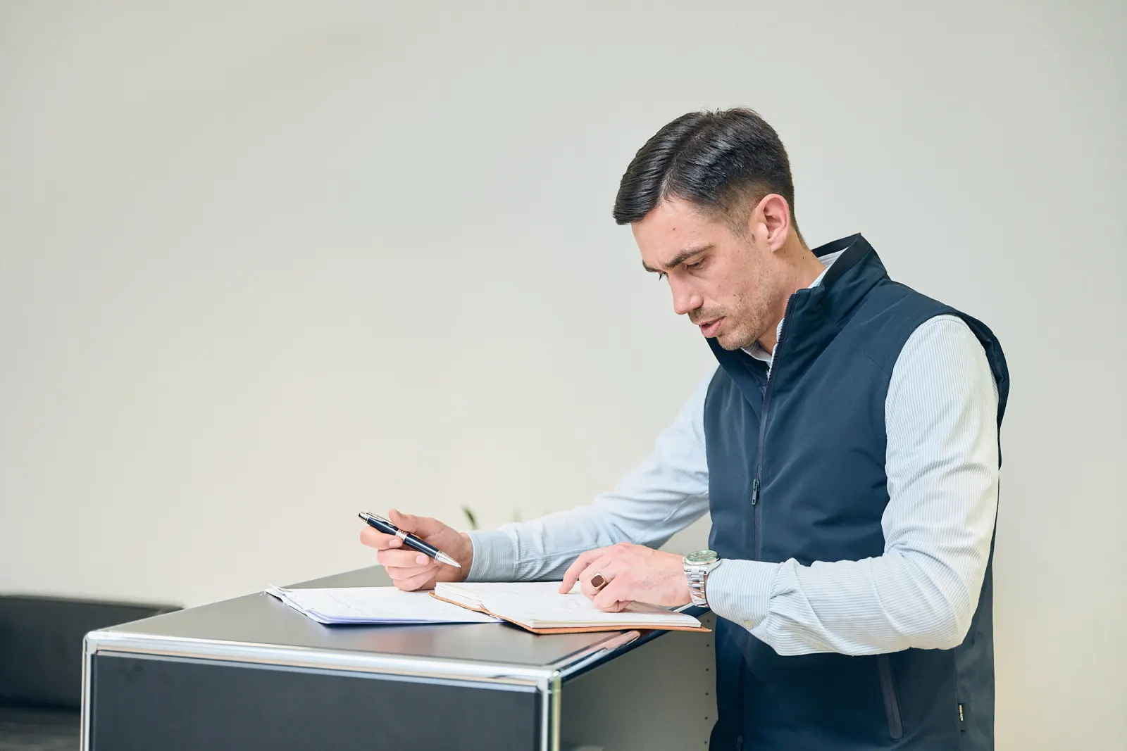 Lukas Becker prüft Unterlagen zur Versicherungspflichtgrenze 2027